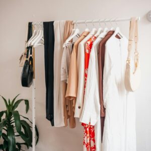 Stylish clothing rack with dresses and accessories in a boutique interior.